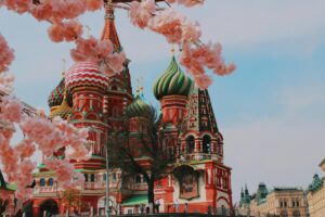 About Saint Basil's Cathedral in Moscow framed by cherry blossoms, showcasing vibrant Russian architecture.